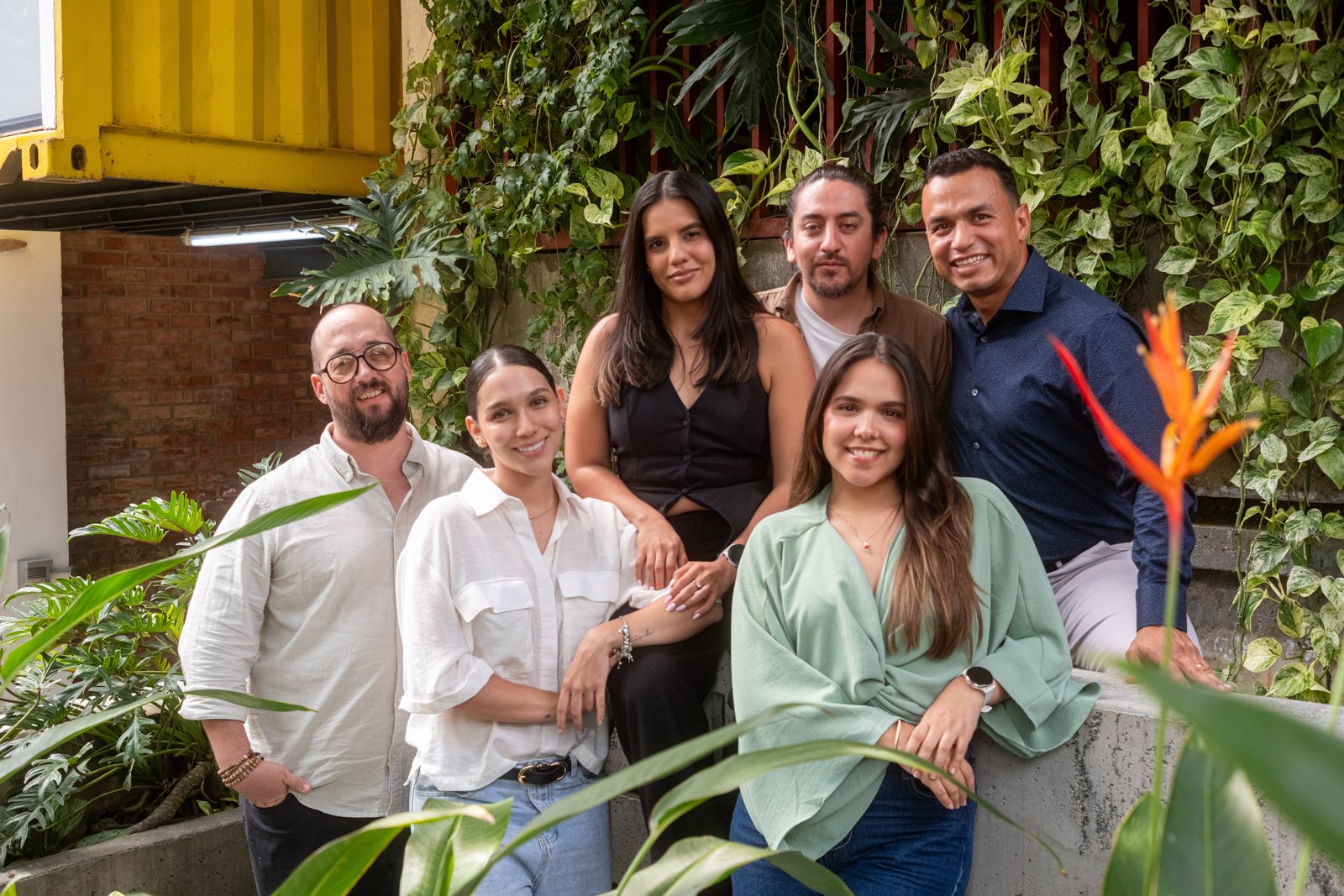 The Latinovation team of six, together against a green plant wall
